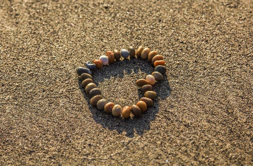 Stone heart arranged on sandy beach cremation services LaPlace, LA