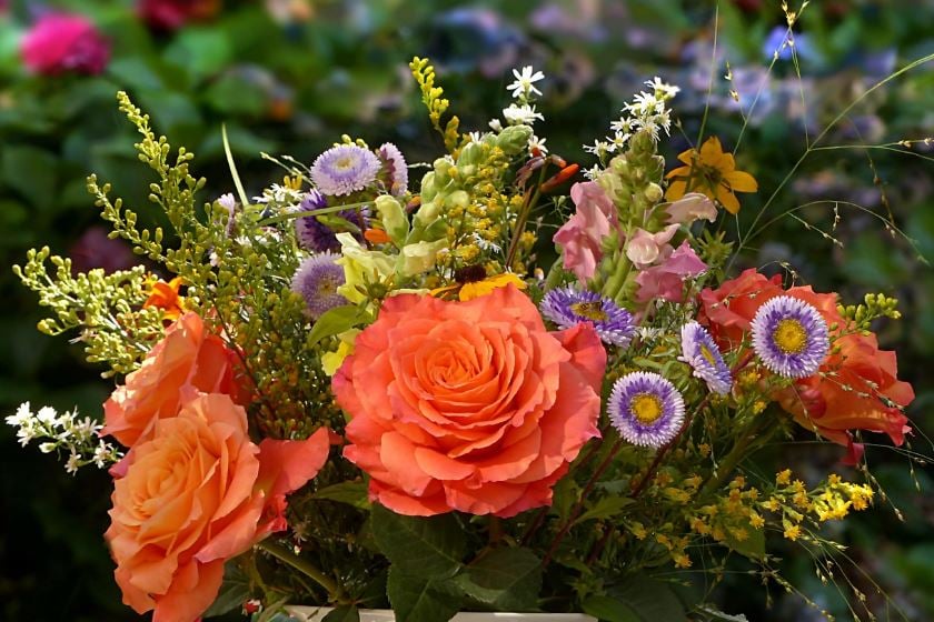 Garden-style floral arrangement with orange roses, cremation services Garyville, LA