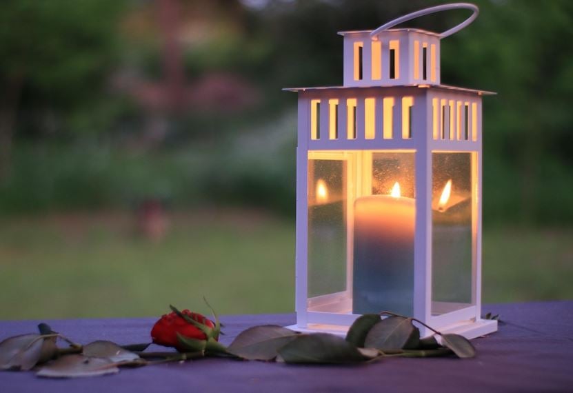 Memorial lantern lit at dusk with single red rose, healing moments, cremation services LaPlace, LA
